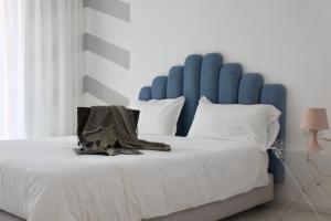 特罗佩阿S'O Suites Tropea的一张带蓝色床头板和白色枕头的大床