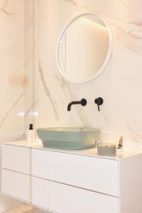 特罗佩阿S'O Suites Tropea的浴室设有水槽和梳妆台上的镜子