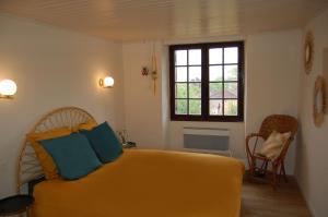 CendrieuxLOU CLEDOU的一间卧室设有黄色的床和窗户。
