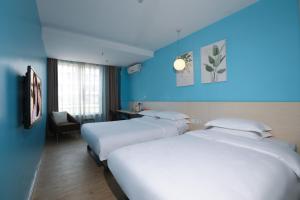 深圳卡罗精品酒店 - 蛇口店的两张位于酒店客房的床,拥有蓝色的墙壁