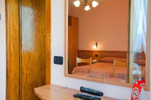 卡斯蒂奥内·德拉·佩雷索米格里奥拉蒂酒店的一间卧室配有一张床和一面大镜子