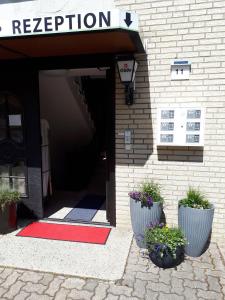 文尼希森卡林贝格霍夫酒店的红色地毯和两株植物的建筑物入口