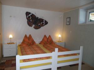 马尔尼茨科妮莉亚公寓的卧室配有一张床上,墙上挂着蝴蝶