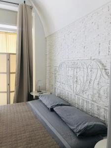 滨海波利尼亚诺ZI' MARI' - Via Roma的卧室内的一张床位,卧室拥有白色砖墙