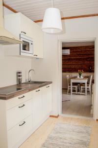 哈普萨卢Wiedemanni Apartment的一间带白色橱柜的厨房和一间带桌子的用餐室