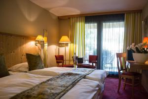 维桑堡磨坊德拉城酒店的酒店客房带一张床、一张桌子和椅子