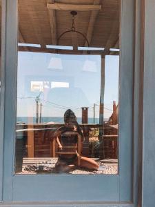 德尔迪阿布罗角Cabañas Kundalini Punta del Diablo的坐在窗子中的女人的反射
