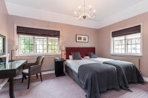 沃金Gorse Hill Hotel的卧室配有一张床、一张书桌和窗户。