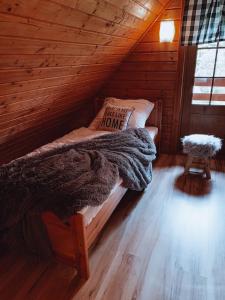 库多瓦-兹德鲁伊Domki u Basi的小木屋内的一张床铺,上面有枕头