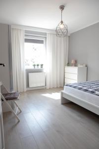 马尔堡Apartament Scandic的白色的卧室设有床和窗户