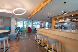 里斯本里斯本机场智选假日酒店的一间设有蓝色凳子的餐厅内的酒吧