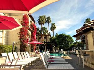 棕榈泉贝斯特韦斯特拉斯布来萨酒店的一组椅子和遮阳伞,位于游泳池旁