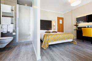 洛桑贝勒里夫酒店的一间卧室配有一张床,浴室设有淋浴。