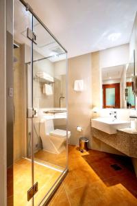 多哈Al Liwan Suites Rawdat Al Khail的一间带玻璃淋浴和水槽的浴室