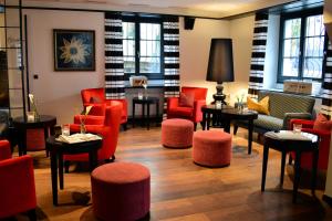 豪尔根Romantik Hotel Schwan的一间设有红色椅子和桌子的等候室