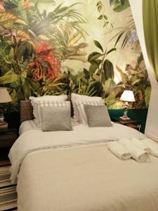 多维尔Magnifique deux pièces au calme的一间卧室配有一张带热带壁纸的大床