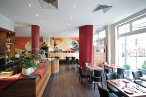 索林根格拉夫哈塔霍夫酒店的一间设有红色柱子和桌椅的餐厅