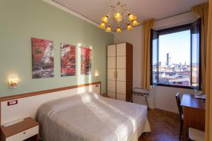佛罗伦萨鲁比诺住宿加早餐旅馆的一间卧室配有一张床、一张书桌和一个窗户。