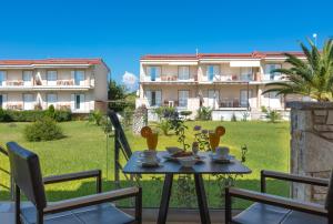 阿尔库季岛Ionion Beach Apartment Hotel & Spa的一个带桌椅的庭院和一座建筑