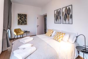 洛迦诺Villa Muralto Rooms & Garden的卧室配有带枕头的大型白色床