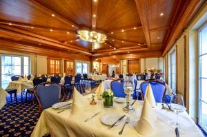 埃尔肯罗特兰德霍斯克鲁巴酒店的宴会厅配有桌椅和吊灯。