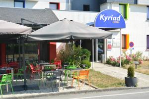 尚特皮Kyriad Rennes Sud - Cesson Chantepie的一间带桌椅和遮阳伞的餐厅