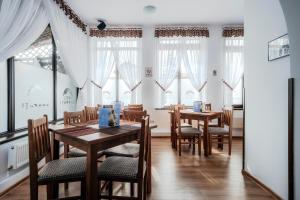 古拉哈莫卢洛伊Hotel Carpati的用餐室设有桌椅和窗户。