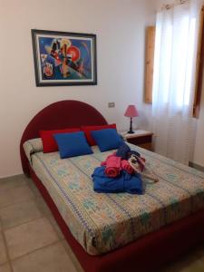 比蒂B&B Roseddu的一间卧室配有蓝色和红色枕头的床