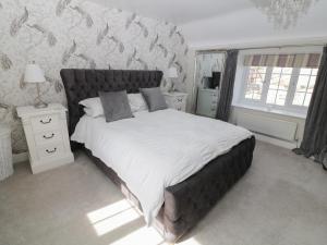 林肯Farriers Cottage的一间卧室配有一张带白色床单的大床