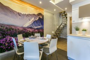 扎科帕内斯塔拉波拉纳VIP公寓的一间设有桌子和紫色鲜花的用餐室