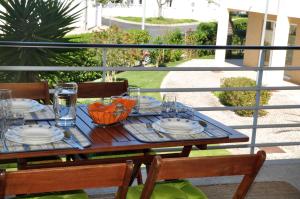 阿尔沃尔SweetHome at Vila da Praia的阳台上的桌子上摆放着盘子和玻璃杯