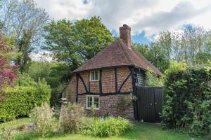 法弗舍姆Walnut Tree Cottage by Bloom Stays的花园中带门的老房子