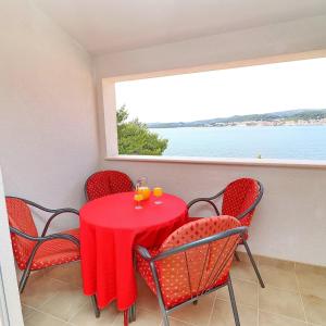 奥瑞比克Apartments Marko Pelješac的红色的桌椅,享有海景