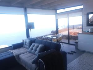 丰卡连特德拉帕尔马Casa El Mirador的客厅设有蓝色的沙发和大窗户