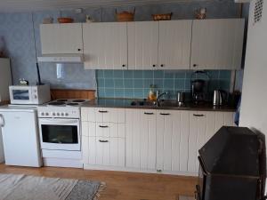 TynkäKesäranta的厨房配有白色橱柜和白色炉灶烤箱。