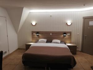 Linter阿肯那提酒店的一间卧室配有一张大床,墙上有两盏灯