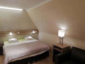 Linter阿肯那提酒店的一间卧室配有床、沙发和灯