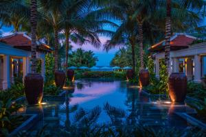 金兰The Anam Cam Ranh的夜间棕榈树度假村泳池