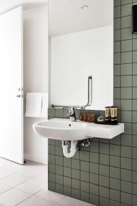 墨尔本Lanbruk Richmond Hill的浴室铺有绿色瓷砖,配有白色水槽。