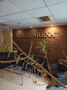 雷布尼克Hotel Arena的酒店区域设有皮革沙发和砖墙