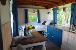 沃尔克姆维尔根住宿加早餐酒店的客房设有桌子和一张带蓝色窗帘的床。