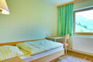 莱赫阿尔贝格Der Lecher的一间卧室配有一张床、一张书桌和一个窗户。