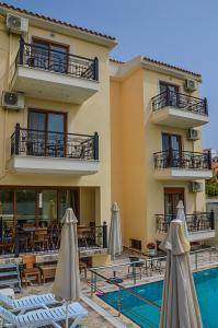 斯基亚索斯镇雅典娜一室公寓酒店的酒店设有一个游泳池、桌子和遮阳伞