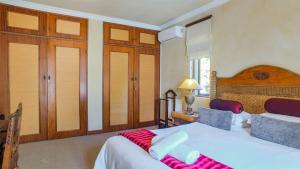 约翰内斯堡卢加诺别墅宾馆的卧室配有一张白色大床和木制床头板