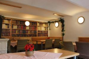 泽勒兹纳·鲁达Penzion Pohádka的一间带桌椅和书架的餐厅