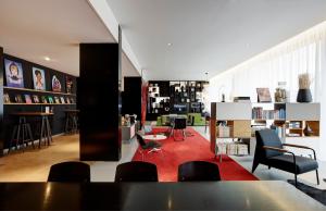 史基浦阿姆斯特丹史基浦机场世民酒店的客厅配有椅子和红色地毯