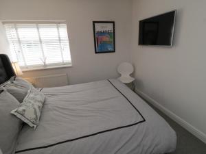 惠特比Flat 3, Peacehaven的卧室配有一张床铺,墙上配有电视