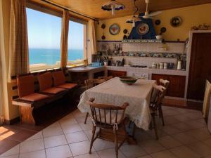 夏卡Casa vacanze Sciacca的厨房以及带桌子和沙发的客厅。