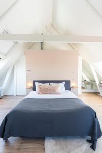 登堡Gravenstraat的一间卧室配有一张带蓝色毯子的大床