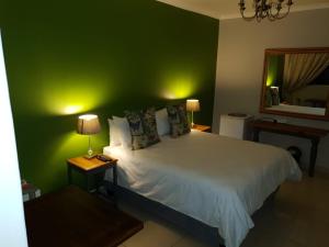 VryburgPoetry Guestrooms的一间卧室配有一张带绿色墙壁的床